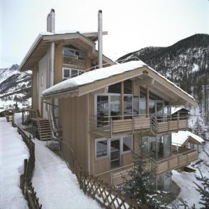 une maison dans la neige avec de la neige dans l'établissement Backstage Hotel Serviced Apartments, à Zermatt
