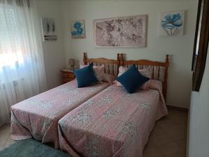 1 dormitorio con 2 camas y almohadas azules en Casa de campo tranquila en vilar cerca de santiago, en Touro