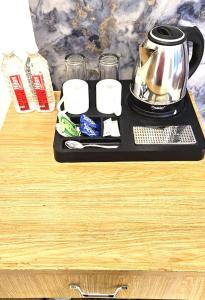 a tray with a tea kettle on a table at The Purezza Residency in Greater Noida