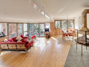 - un salon avec un canapé rouge et une table dans l'établissement Backstage Hotel Serviced Apartments, à Zermatt