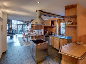 a large kitchen with wooden cabinets and a table at Backstage Hotel Serviced Apartments in Zermatt