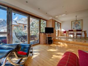 a living room with a view of the mountains at Backstage Hotel Serviced Apartments in Zermatt