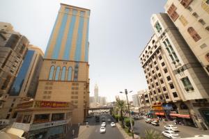 麥加的住宿－Manarat Gaza Hotel - Al Haram Tower，一条繁忙的城市街道,高楼前有汽车