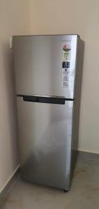 - un réfrigérateur en argent dans la pièce dans l'établissement VR HOTEL, à Auraiya