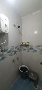 La salle de bains est pourvue de toilettes et d'un seau. dans l'établissement VR HOTEL, à Auraiya