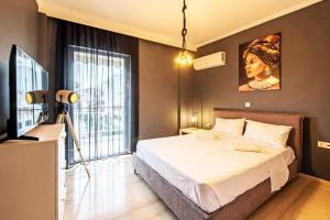 um quarto com uma cama grande e uma televisão em Funky apartment in Zografou em Atenas