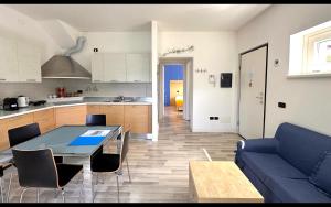 a kitchen and a living room with a blue couch at Gardenia Apartment Ossuccio in Ossuccio +19 photos