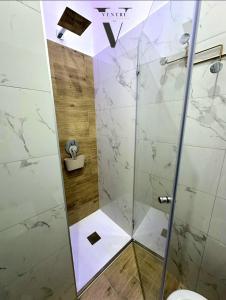a shower with a glass door in a bathroom at Ventre luxury rooms in Naples