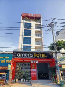 un hotel con un edificio rosso di fronte di Amura Hotel Quận 7 ad Ho Chi Minh