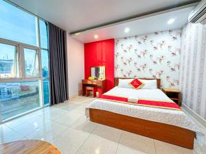 Un dormitorio con una cama y una pared roja. en Amura Hotel Quận 7, en Ho Chi Minh