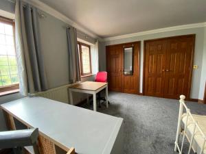 Professional 1-Bed Maisonette in Milton Keynes by HP Accommodation في ميلتون كينز: غرفة بها مكتب وطاولة وكراسي