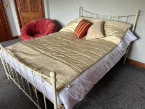 a bed with a metal frame and a red chair at Professional 1-Bed Maisonette in Milton Keynes by HP Accommodation in Milton Keynes