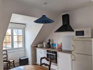 eine Küche mit einem weißen Kühlschrank und einer Mikrowelle in der Unterkunft Appartement face à la plage du val André in Pléneuf-Val-André