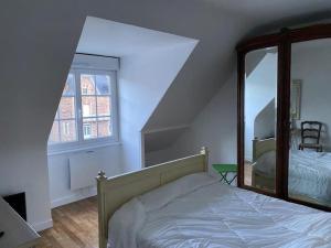 Schlafzimmer mit einem Bett und einem Spiegel in der Unterkunft Appartement face à la plage du val André in Pléneuf-Val-André