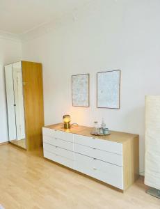 a white dresser in a room with a mirror at Helle Altbauwohnung, tolle Lage in Berlin
