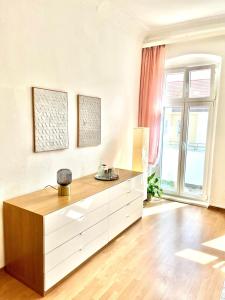 a living room with a dresser and a large window at Helle Altbauwohnung, tolle Lage in Berlin