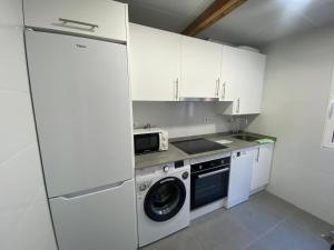 a kitchen with a washing machine and a microwave at Santa Olalla en el norte in Santander