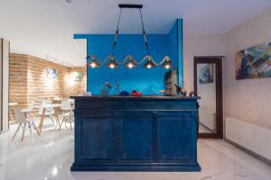 cocina con pared azul y comedor en Kraveli Hotel en Tiflis