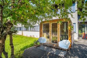 zwei Stühle auf einer Terrasse neben einem Haus in der Unterkunft Voss Vandrarheim Hostel in Vossevangen