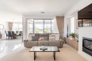 NorthfieldModern Mansion in Lightsview By Host Solutions的带沙发和桌子的客厅