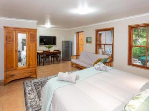a bedroom with a bed and a living room at Columbia in Oudtshoorn