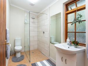 a bathroom with a shower and a toilet and a sink at Columbia in Oudtshoorn +19 photos