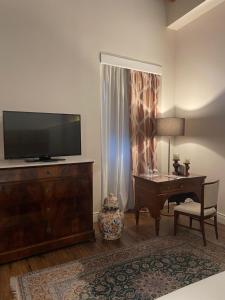 sala de estar con TV de pantalla plana y escritorio en Residenza Palazzo Fortuna - Boutique Hotel, en Civita Castellana