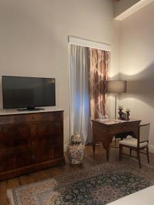 A television and/or entertainment centre at Residenza Palazzo Fortuna - Boutique Hotel