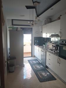 a kitchen with white cabinets and a rug on the floor at Ssana in Aïn Harrouda