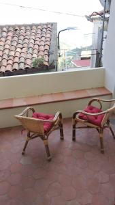 2 Stühle mit roten Kissen auf dem Balkon in der Unterkunft BELLAVISTa in Casalvecchio Siculo