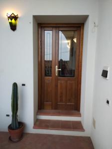 eine Holztür mit einem Kaktus davor in der Unterkunft BELLAVISTa in Casalvecchio Siculo