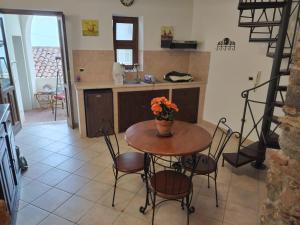 eine Küche mit einem Tisch und einer Blumenvase darauf in der Unterkunft BELLAVISTa in Casalvecchio Siculo
