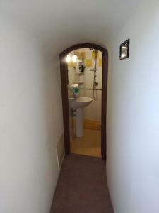 einen Flur mit einem Bad mit einem Waschbecken und einem Spiegel in der Unterkunft BELLAVISTa in Casalvecchio Siculo