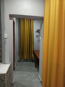 un pasillo con una cortina amarilla y una mesa en Orchard Mist Lodges and Events en Kabwe