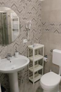 La salle de bains est pourvue d'un lavabo, de toilettes et d'un miroir. dans l'établissement Sperlonga Center Holiday, à Sperlonga