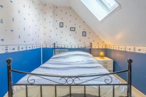a bedroom with a blue and white wall at Maison Gavres - Bord de mer in Gâvres
