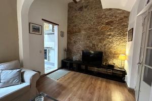a living room with a couch and a stone wall at Lovely House in Sant Feliu in Sant Feliu de Guixols