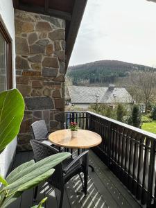 um pátio com uma mesa e cadeiras numa varanda em Zum Wilzenberg em Schmallenberg