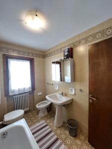 a bathroom with a sink and a toilet and a mirror at Quadrilocale Alberti - Residence dei Fiori in Madonna di Campiglio
