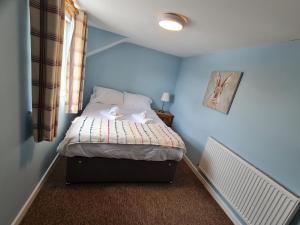 a small bedroom with a bed with two dolls on it at The Riverside in Lechlade