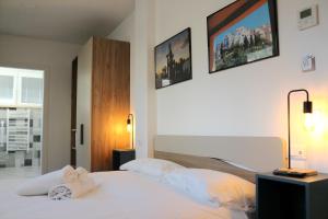 um quarto com uma cama branca e duas fotografias na parede em Sperlonga Center Holiday em Sperlonga