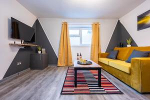 a living room with a yellow couch and a table at Free Parking - The Coach House B by Tŷ SA in Cardiff