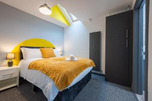 a bedroom with a large bed with a yellow headboard at Free Parking - The Coach House B by Tŷ SA in Cardiff