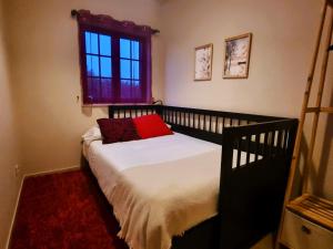 Un dormitorio con una cama con una almohada roja. en Monte dos Manos - sábado a sábado Julho a Setembro, 