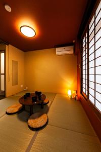 una habitación con una mesa y dos asientos en una habitación en おやど紀伊国屋伊勢町, en Asahimachi