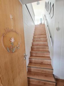 una escalera con una puerta de madera que conduce a una escalera en Ferienwohnung Kleine Auszeit, en Sankt Englmar