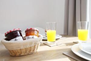 a table with a basket of food and glasses of orange juice at Gwent View by Tŷ SA in Newport