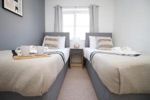 two beds sitting next to each other in a bedroom at Gwent View by Tŷ SA in Newport