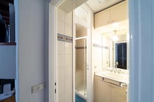 La salle de bains est pourvue d'un lavabo et d'un miroir. dans l'établissement HBHALL Navigli 2 Apartment, à Milan