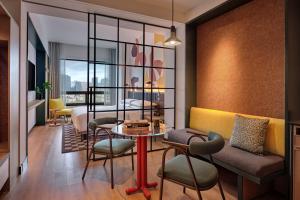 een kamer met een bed en een tafel en stoelen bij Caption by Hyatt Zhongshan Park Shanghai in Shanghai